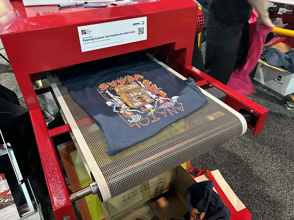 T-shirts curing ink on a conveyor dryer after screen printing